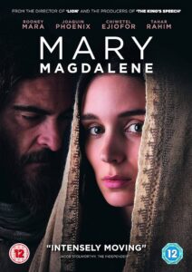 A poster for the film Mary Magdalene. A close-up of a young white woman looking at us, her face covered by an embroidered shawl. In the background, but still close, a white bearded man looks intensely towards the ground.